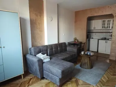 a living room with a couch and a kitchen at Dona Apartments 1 in Niš