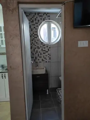 a bathroom with a sink and a round window at Dona Apartments 1 in Niš