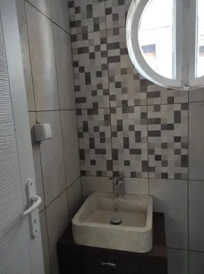 a bathroom with a sink with a mirror and a window at Dona Apartments 1 in Niš