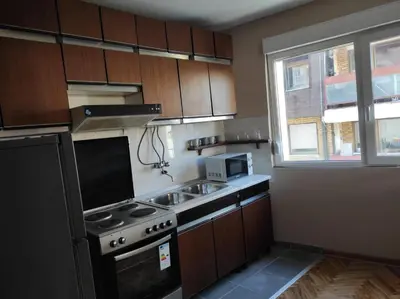 a kitchen with a stove and a sink and a window at Dona Apartments 2 in Niš