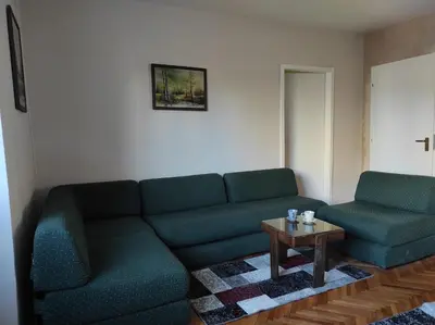 a living room with a couch and a table at Dona Apartments 2 in Niš