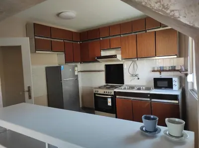 a kitchen with wooden cabinets and stainless steel appliances at Dona Apartments 2 in Niš