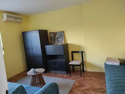 a living room with a blue couch and a chair at Dona Apartments 2 in Niš
