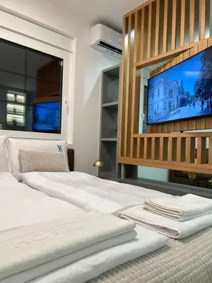 a bedroom with a large bed and a flat screen tv at Apartmani Central 3 & Free parking garage in Vrnjačka Banja
