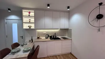 a kitchen with white cabinets and a table with chairs at Apartmani Central 3 & Free parking garage in Vrnjačka Banja