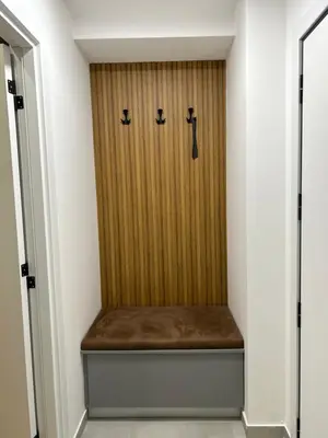 a room with a wooden door with a bench at Apartmani Central 3 & Free parking garage in Vrnjačka Banja