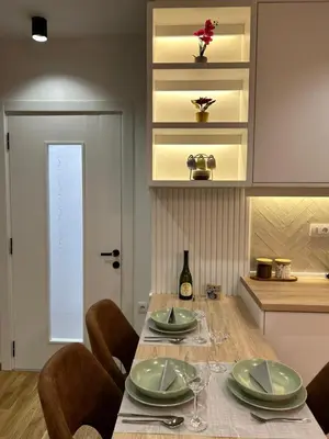 a kitchen with a table with plates and wine glasses at Apartmani Central 3 & Free parking garage in Vrnjačka Banja