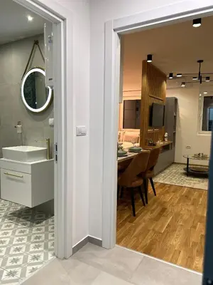 a bathroom with a sink and a dining room at Apartmani Central 3 & Free parking garage in Vrnjačka Banja