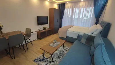 a living room with a blue couch and a bed at Apartment 12 Kopaonik in Kopaonik