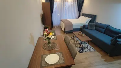 a living room with a blue couch and a table at Apartment 12 Kopaonik in Kopaonik