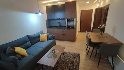 a living room with a blue couch and a table at Apartment 12 Kopaonik in Kopaonik