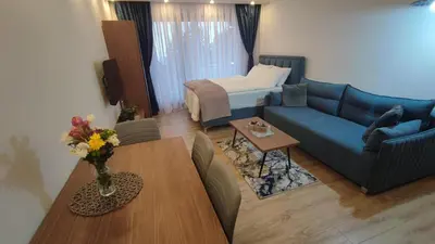 a living room with a blue couch and a table at Apartment 12 Kopaonik in Kopaonik