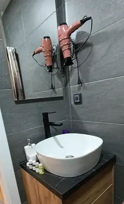 a bathroom with a white sink and a mirror at Apartman 