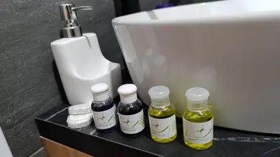 four bottles of oils sitting on a counter next to a sink at Apartman 