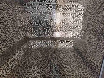 a bathroom with a shower with tiled walls at Apartman 