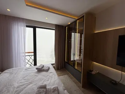 a bedroom with a bed and a large window at Fashion Residence Hill in Kopaonik