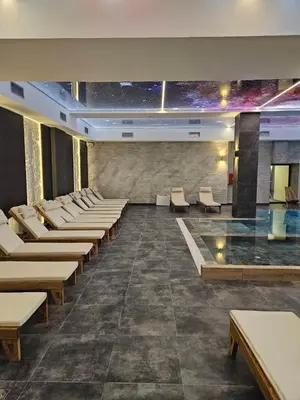 a waiting room with white chairs and a pool at Fashion Residence Hill in Kopaonik