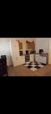 a kitchen with white cabinets and a checkered floor at V&Ž-Vb in Vrnjačka Banja
