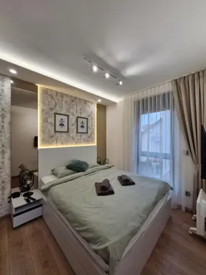 a bedroom with a large bed and a large window at VIRTUS apartmani Vrnjačka Banja centar in Vrnjačka Banja