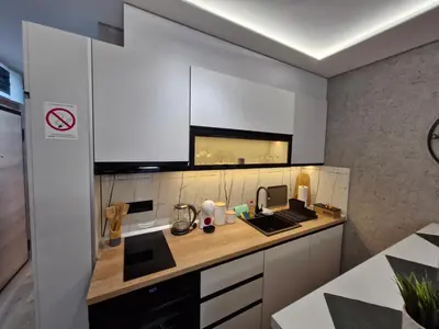 a kitchen with white cabinets and a counter top at VIRTUS apartmani Vrnjačka Banja centar in Vrnjačka Banja