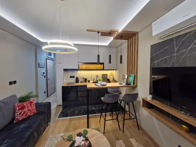 a living room with a couch and a kitchen at VIRTUS apartmani Vrnjačka Banja centar in Vrnjačka Banja