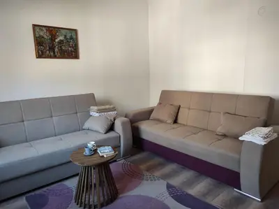 a living room with two couches and a table at Dona Rooms 3 in Niš