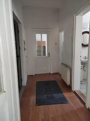 an empty room with a hallway with a door and a rug at Dona Rooms 3 in Niš