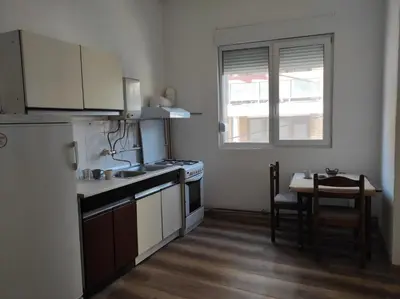 a kitchen with a sink and a table in it at Dona Rooms 3 in Niš