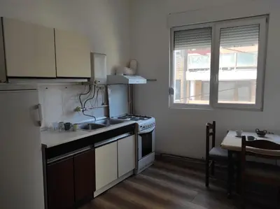 a kitchen with a stove and a sink and a window at Dona Rooms 3 in Niš