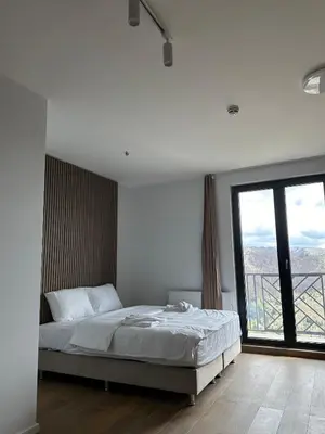 a bedroom with a bed and a large window at Ocean Vikend naselje Kopaonik in Kopaonik