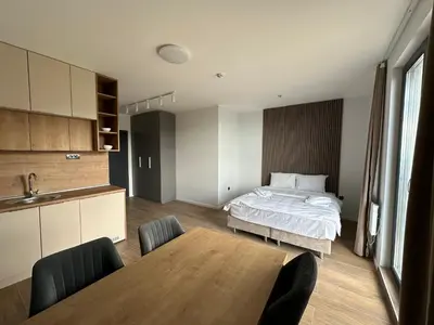 a bedroom with a bed and a table with chairs at Ocean Vikend naselje Kopaonik in Kopaonik