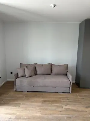 a couch in a room with a white wall at Ocean Vikend naselje Kopaonik in Kopaonik