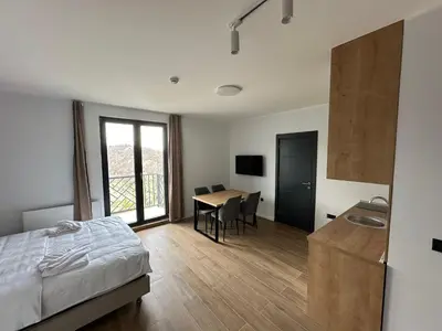 a bedroom with a bed and a table with chairs at Ocean Vikend naselje Kopaonik in Kopaonik