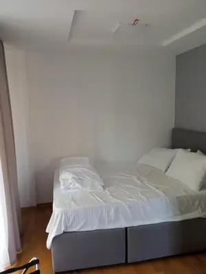 a bed in a room with a white wall at Vila Barselona Kopaonik in Raška