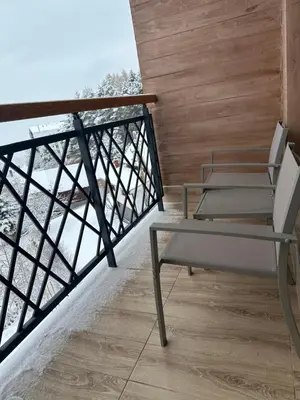 a balcony with two chairs and a railing at Waves Kopaonik, Residence Hill in Kopaonik