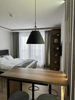 a bedroom with a table and a bed and a large lamp at Waves Kopaonik, Residence Hill in Kopaonik