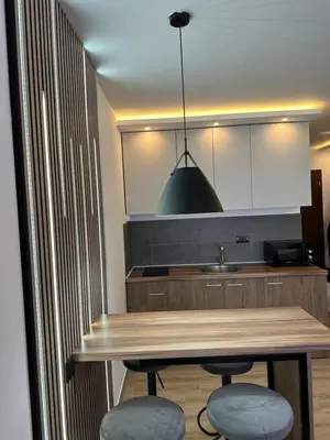 a kitchen with a wooden table and two stools at Waves Kopaonik, Residence Hill in Kopaonik