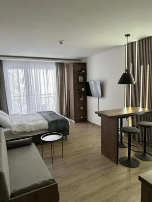 a hotel room with a bed and a table and a couch at Waves Kopaonik, Residence Hill in Kopaonik