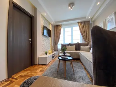a living room with a couch and a table at LaKop Apartman in Kopaonik
