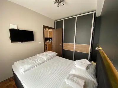a bedroom with a bed and a flat screen tv at LaKop Apartman in Kopaonik