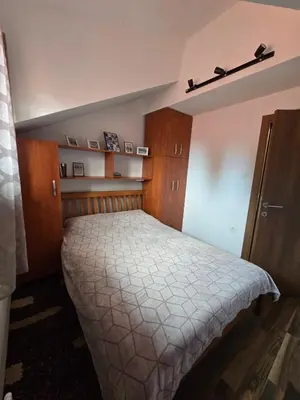 a bedroom with a bed and wooden cabinets at Apartman Leda in Kopaonik