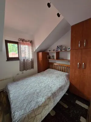 a bedroom with a bed and wooden cabinets and a window at Apartman Leda in Kopaonik
