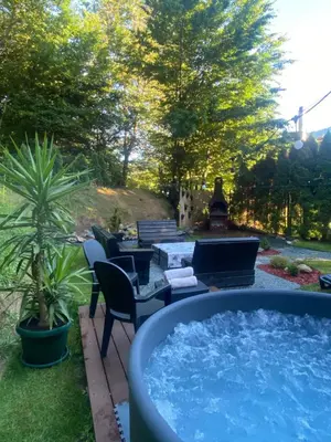 a hot tub in a yard with chairs and a table at Vila Krnjević Jastrebac in Buci