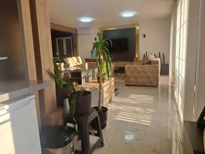 a living room with potted plants on the floor at Dina lux apartman 2 in Jagodina