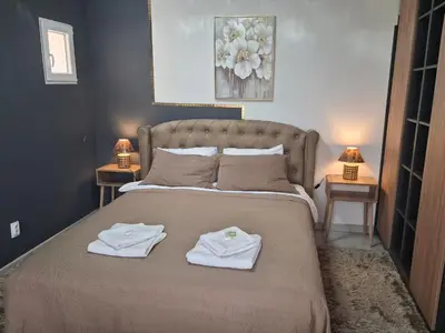 a bedroom with a bed with two towels on it at Dina lux apartman 2 in Jagodina