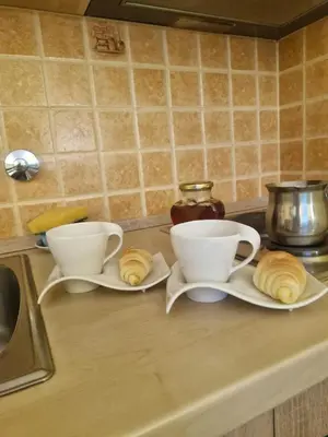 two coffee cups and croissants on a kitchen counter at Mina in Kopaonik