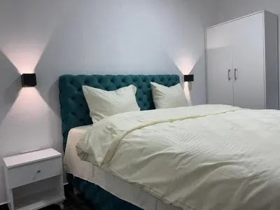 a bedroom with a large bed with a blue headboard at Vila Banovic in Kopaonik