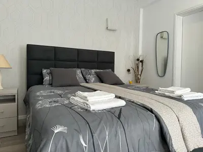 a bedroom with a bed with towels on it at Sofy apartman in Niš