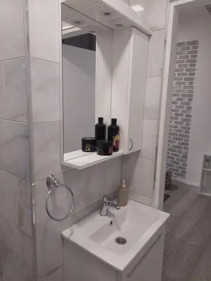 a bathroom with a white sink and a mirror at Sofy apartman in Niš