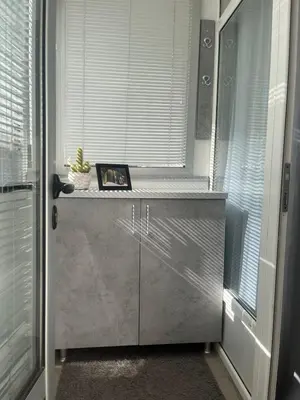 a kitchen with a window and a counter with a plant on it at Sofy apartman in Niš